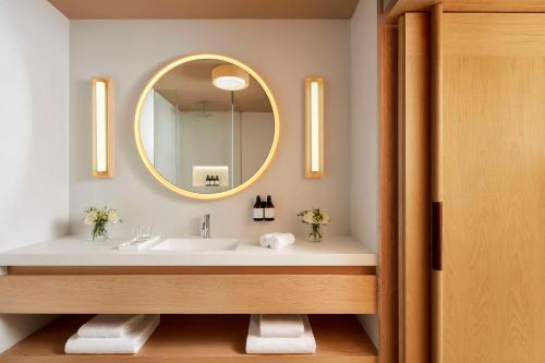 a bathroom with a sink and a mirror at Tivoli Estela Golf & Lodges Porto in Póvoa de Varzim