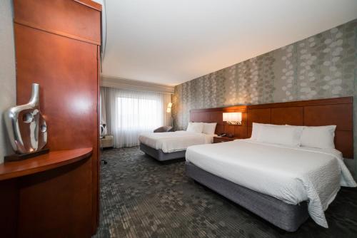 a hotel room with two beds and a television at Courtyard by Marriott Vicksburg in Vicksburg