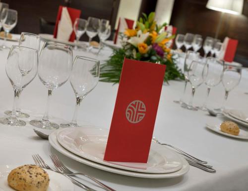 a table with plates and wine glasses on a table at NH Collection Victoria in Granada