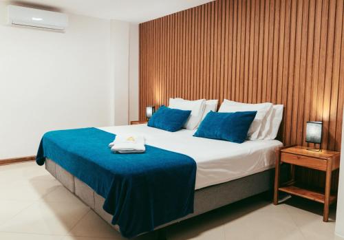 a bedroom with a large bed with blue sheets at Fernandina Hotel & Spa in Puerto Ayora
