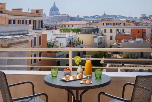a table on a balcony with a view of a city at NH Collection Roma Giustiniano in Rome