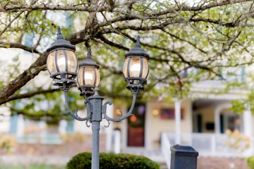 two lights on a pole in front of a tree at Montgomery Inn BnB in Versailles