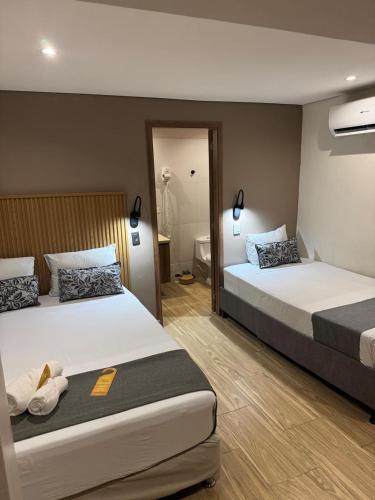 a hotel room with two beds and a bathroom at Casa Roman Hotel Boutique in Cartagena de Indias