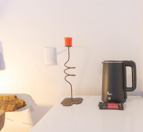 a coffee maker and a candle on a table at Sapê Guest Hotel in Praia do Rosa