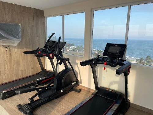 two exercise bikes in a room with windows at Luxury 2-Bedroom Apartment with amazing view - Infinity Pool and Rooftop in Building in Veracruz