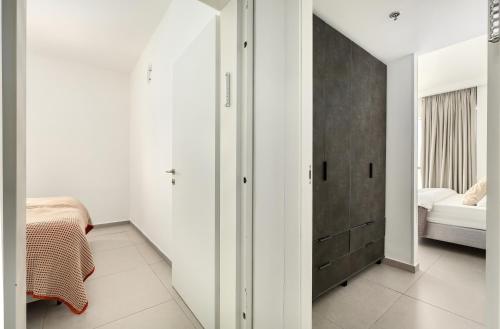 a bedroom with white walls and a bed and a closet at MR savyon view 2BR with balcony in Jerusalem