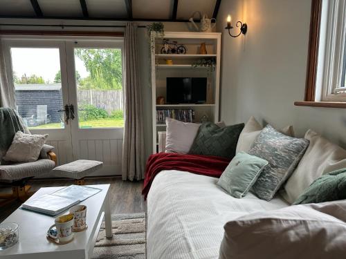 a living room with a couch and a table at Saving Grace with private hot tub in Bawdeswell
