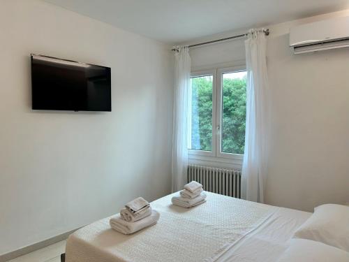 a white bedroom with a bed and a window at Locanda Divinis in Cerea