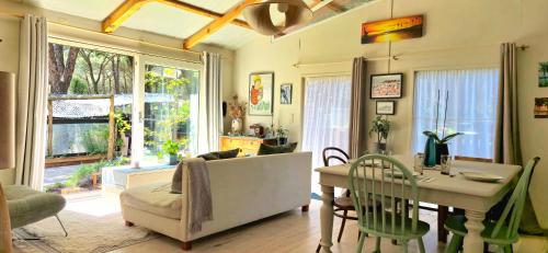 a living room with a table and a dining room at La Cabane Caparica in Charneca