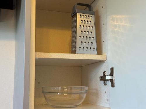 a glass bowl on a shelf next to a sink at Daisy Haven in Southampton in Southampton