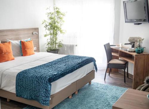 a bedroom with a bed and a desk with a computer at Studio-Parkplatz-Netflix-Balkon in Plochingen
