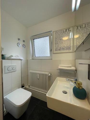 a white bathroom with a toilet and a sink at Studio-Parkplatz-Netflix-Balkon in Plochingen
