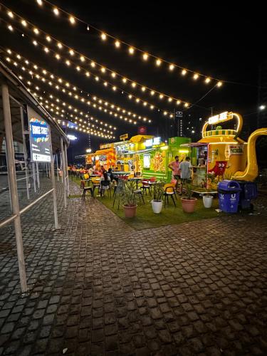 um grupo de food trucks com luzes e mesas em Bell Rooms em Noida