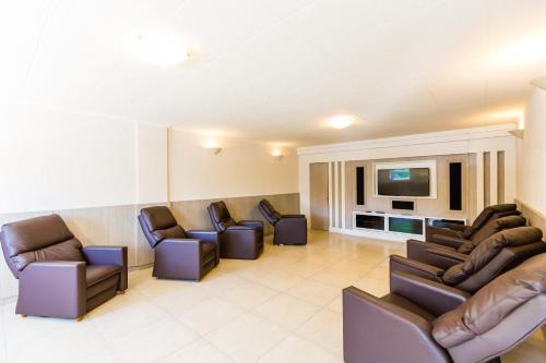 a waiting room with couches and a flat screen tv at Hotel Vila do Farol in Bombinhas