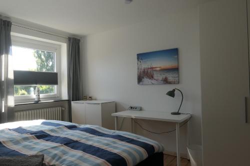 a bedroom with a bed and a desk and a window at FeWo Wrist in Wrist