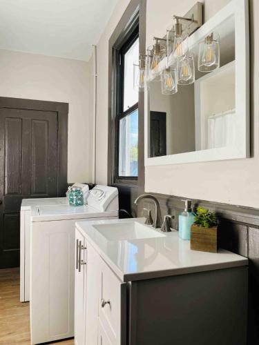 a kitchen with a sink and a washing machine at Suite Home Indiana Apartments in Evansville