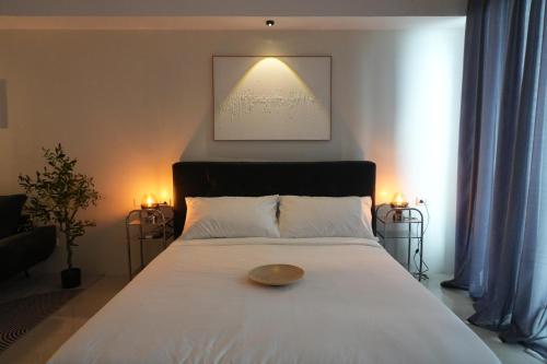 une chambre avec un lit blanc sur lequel se trouve un bol dans l'établissement Bruné - Parañaque, à Manille