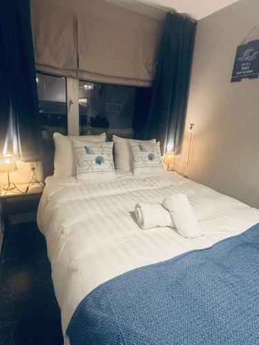 a large white bed with two towels on it at Duin 10 in Katwijk aan Zee