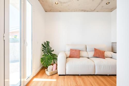 a white couch in a living room with a plant at The Vinehill House in Câmara de Lobos