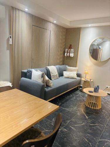 a living room with a blue couch and a table at Duin 10 in Katwijk aan Zee