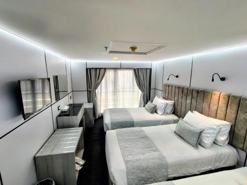 a small room with two beds and a bench in it at M/S Royal Adventure - Saturday from Luxor 4 or 7 Nights - Wednesday from Aswan 3 or 7 Nights in Luxor