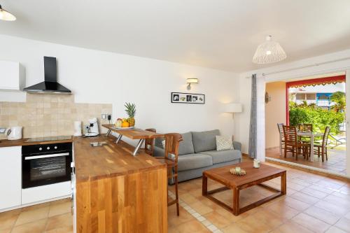 a kitchen and living room with a couch and a table at SALT 5 Sur la plage de la Baie Orientale appart 1ch in Orient Bay