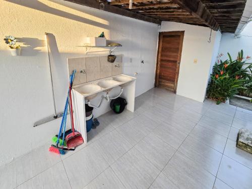 ein Badezimmer mit einem Waschbecken und einem Mopp in der Unterkunft Casa, piscina, churrasqueira, 200m da praia- By OASIS FERIAS in Conde