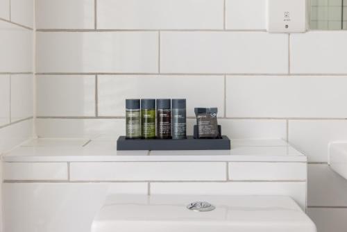 a shelf in a bathroom with books on it at Covent Garden Apartments - Netflix and Nespresso in London