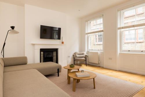 a living room with a couch and a fireplace at Covent Garden Apartments - Netflix and Nespresso in London