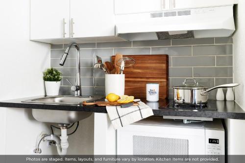 a kitchen counter with a sink and a stove at InTown Suites Extended Stay Savannah GA in Savannah