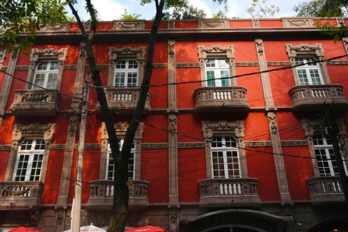 a red building with white windows and balconies at Casa Amelio Roma Norte in Mexico City