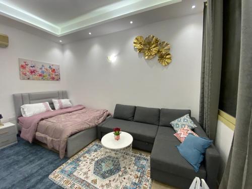 a living room with a couch and a bed at Furnished studio in ‘Aqbīyah