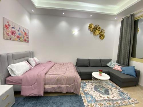 a bedroom with a bed and a couch at Furnished studio in ‘Aqbīyah