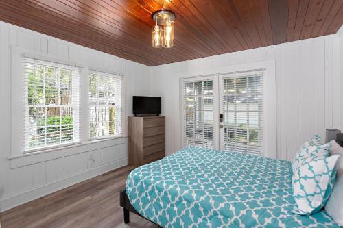a bedroom with a bed and a tv and windows at 559 Magnolia Ave in Demere Park