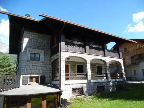una grande casa in mattoni con balcone sul lato anteriore di Trilocale zona funivie a Bormio a Bormio