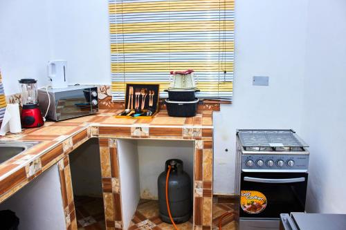 a kitchen with a counter top with a stove at Heiligtum Des Herrn Hotel in Winneba