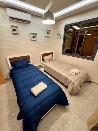 マラケシュにあるLuxury apartment in Guelizのベッド2台と鏡のある寝室