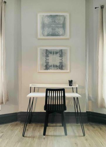 a white table with a black chair in a room at Suite Home Indiana Apartments in Evansville