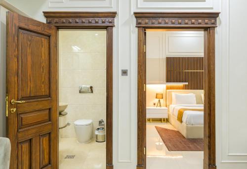 a bathroom with a bedroom with a bed and a toilet at Abraj INN Royal Hotel فندق أبراج إن الملكي in Doha