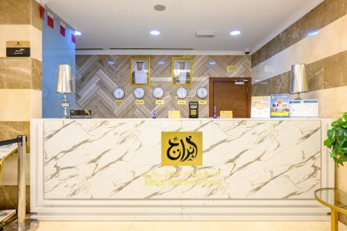 a lobby with a counter with clocks on the wall at Abraj INN Royal Hotel فندق أبراج إن الملكي in Doha