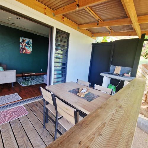 a wooden table and chairs on a deck at Fare Toahana, logement chez l'habitant in Faaa