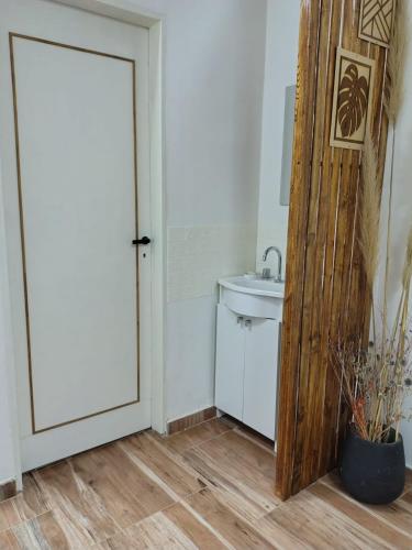 a bathroom with a white sink and a door at Refugio Urbano 2 in Corrientes