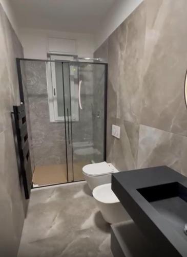 a bathroom with a toilet and a glass shower at Bresso House in Bresso