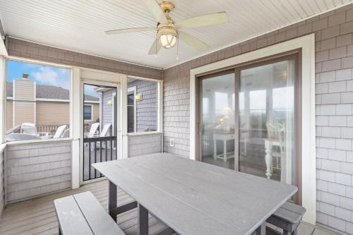 a table on a screened porch with a ceiling fan at 2064 - Just Ducky II in Poteskeet Village