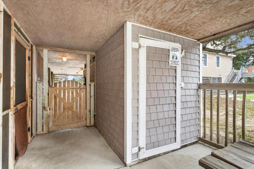 a garage with a wooden door and a porch at 2064 - Just Ducky II in Poteskeet Village