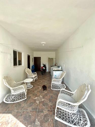 a room with white chairs and a dog sitting on the floor at Casa Tipo Villa, Piscina, Playas De RSJ a 4 min in Río San Juan