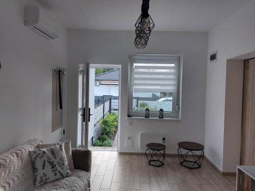 a living room with a couch and a window at Három Testvér Apartman in Siófok