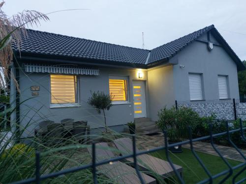 a house with a fence in front of it at Három Testvér Apartman in Siófok
