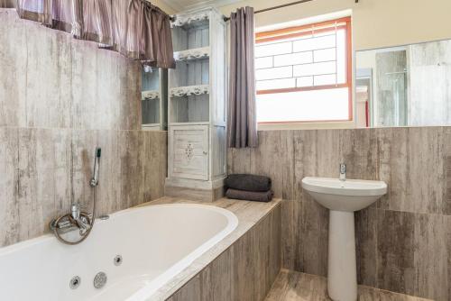 Un baño con bañera, inodoro y lavabo. en Safe, Accessible Venue Near Muizenberg for Accommodation and Events, en Ciudad del Cabo