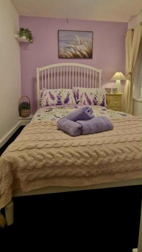 ein Bett mit lila Wänden und lila Kissen darauf in der Unterkunft Taff Cottage - Free parking, Fast Wifi, Cosy vibe in Cardiff